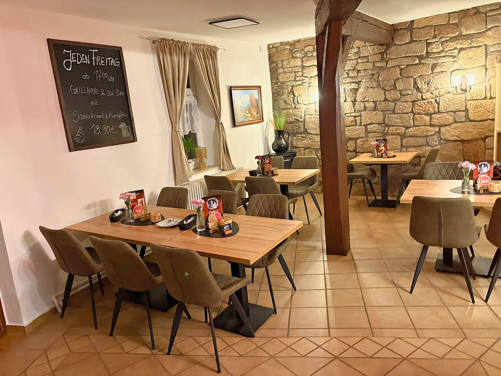 Gaststube mit Natursteinwand und Fachwerkbalken