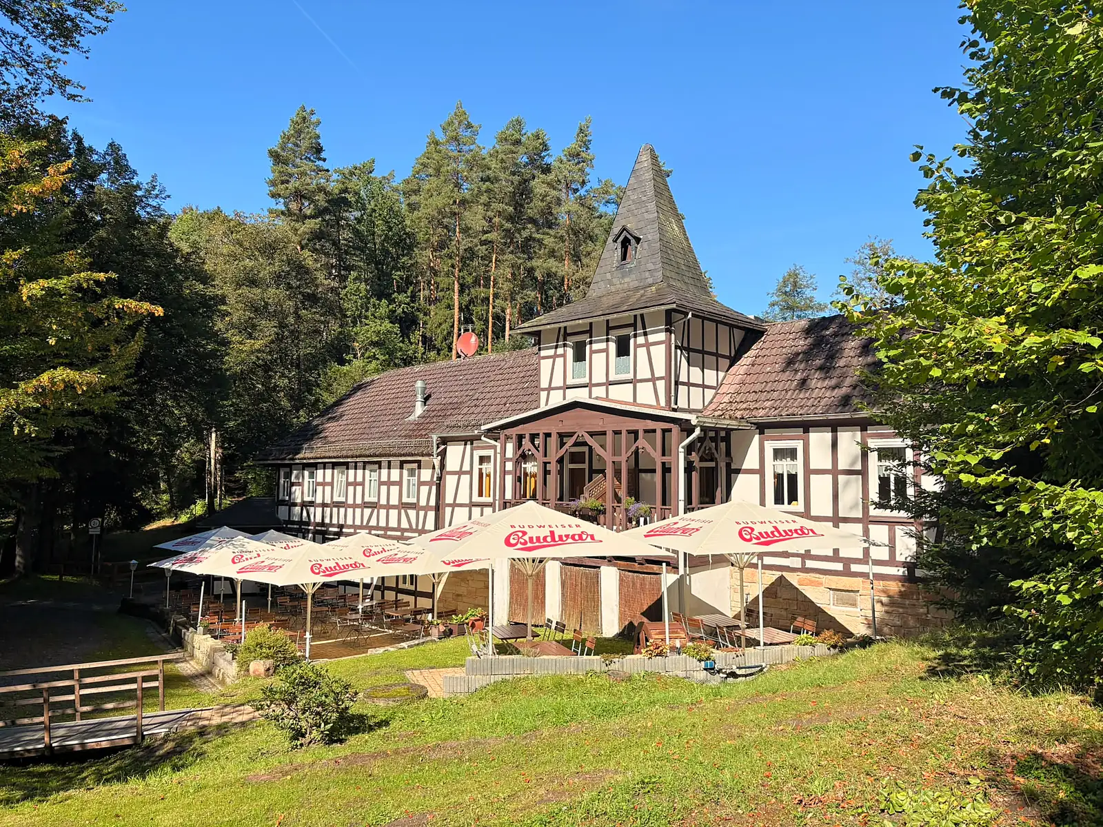 Die Weihertalmühle im Sonnenschein, umgeben von Wald