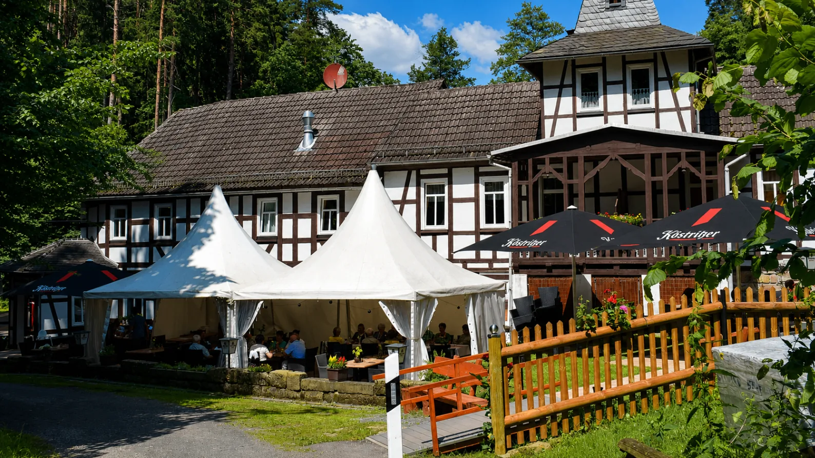 Außengastronomie mit Zelten und Sonnenschirmen an der Weihertalmühle